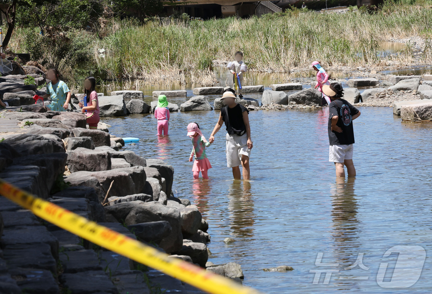 (광주=뉴스1) 박지현 기자 = 광주 동구 광주천 물놀이장에 '운영 잠정 취소'에 통제선을 넘어 시민들은 여전히 하천에서 물놀이를 즐기고 있다. 2025.7.27/뉴스1