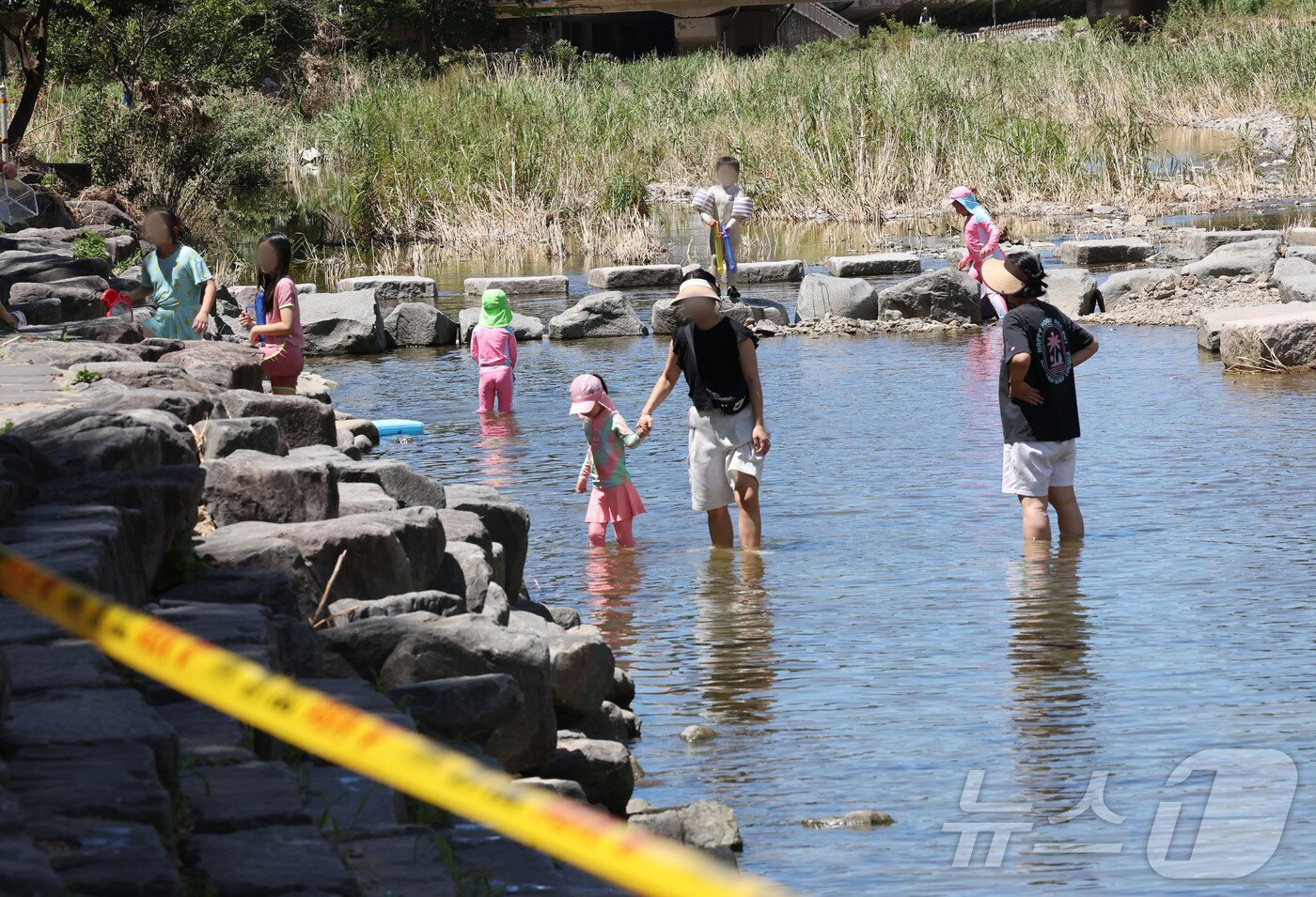 본문 이미지 - 폭염경보가 내려진 27일 광주 동구 용산동 광주천 물놀이장에 서 시민들이 &#39;운영 잠정 취소&#39; 통제선을 넘어 여전히 하천에서 물놀이를 즐기고 있다. 2025.7.27/뉴스1 ⓒ News1 박지현 기자