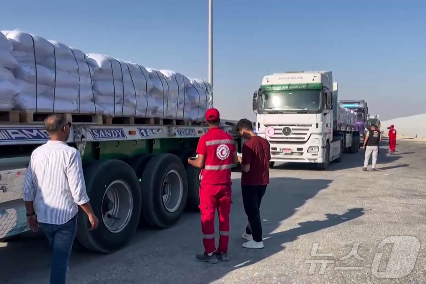 (라파 AFP=뉴스1) 양은하 기자 = 27일(현지시간) 가자지구와 맞닿은 라파 국경 이집트 쪽에 구호 트럭들이 대기 중이다. 이 트럭들은 봉쇄된 팔레스타인 지역으로 들어갈 준비를 …