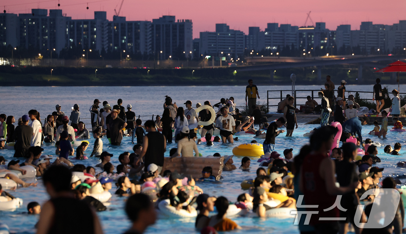 (서울=뉴스1) 김성진 기자 = 전국 대부분 지역에서 열대야가 나타난 27일 서울 마포구 난지한강 물놀이장에서 열린 '2025 한강페스티벌 여름' 한강시네마 퐁당을 찾은 시민들이 …