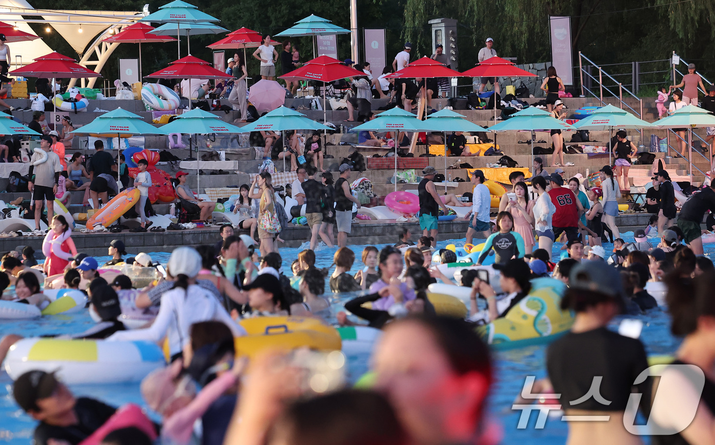(서울=뉴스1) 김성진 기자 = 전국 대부분 지역에서 열대야가 나타난 27일 서울 마포구 난지한강 물놀이장에서 열린 '2025 한강페스티벌 여름' 한강시네마 퐁당을 찾은 시민들이 …