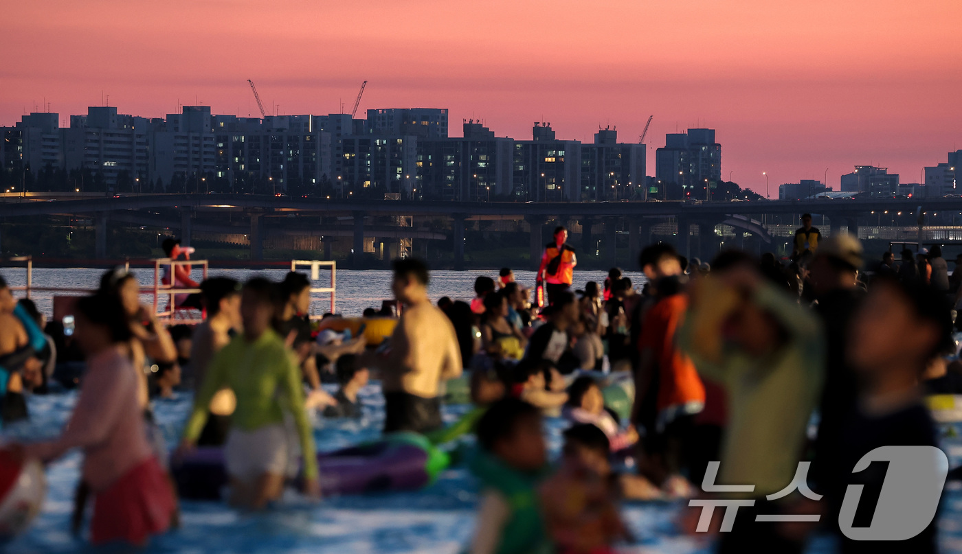 (서울=뉴스1) 김성진 기자 = 전국 대부분 지역에서 열대야가 나타난 27일 서울 마포구 난지한강 물놀이장에서 열린 '2025 한강페스티벌 여름' 한강시네마 퐁당을 찾은 시민들이 …