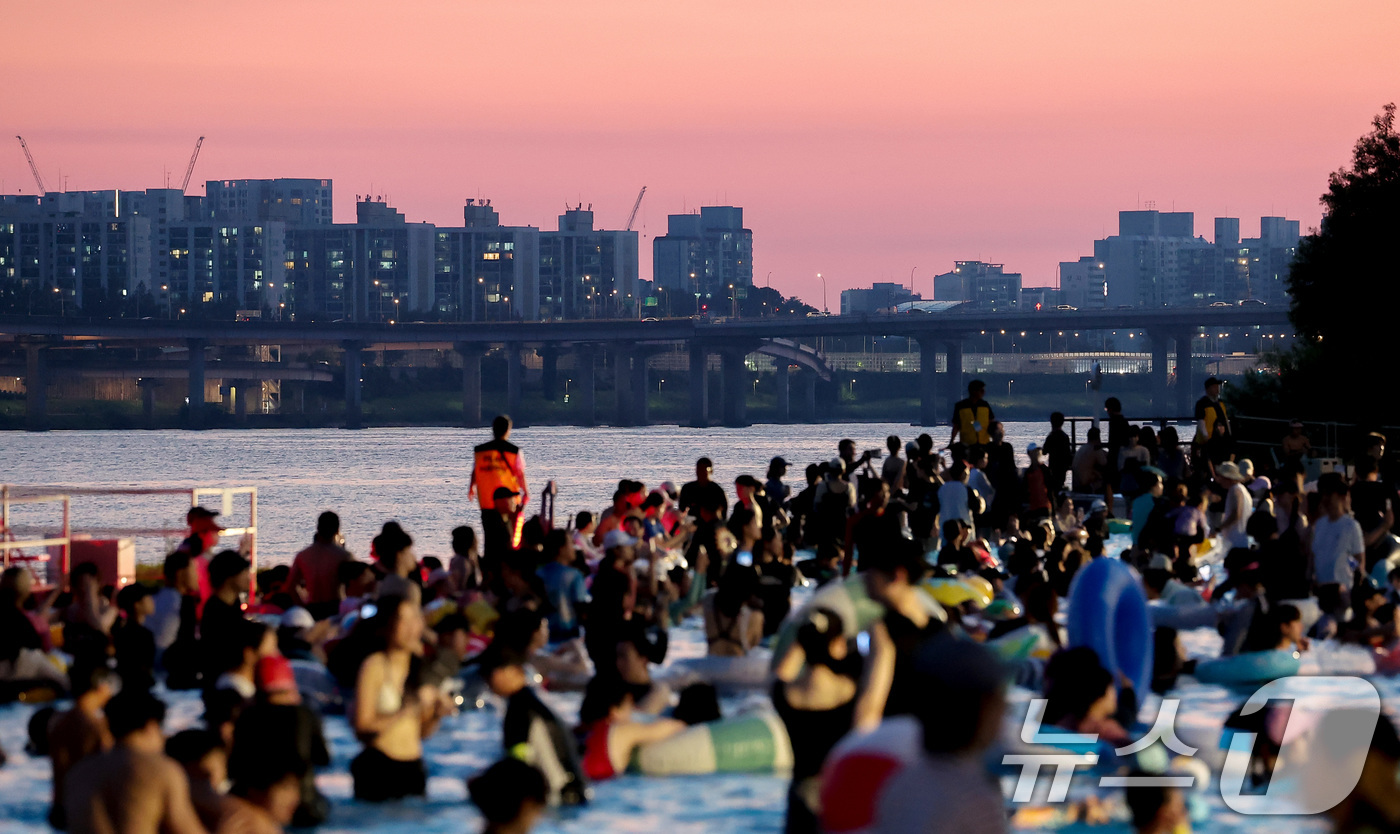 (서울=뉴스1) 김성진 기자 = 전국 대부분 지역에서 열대야가 나타난 27일 서울 마포구 난지한강 물놀이장에서 열린 '2025 한강페스티벌 여름' 한강시네마 퐁당을 찾은 시민들이 …