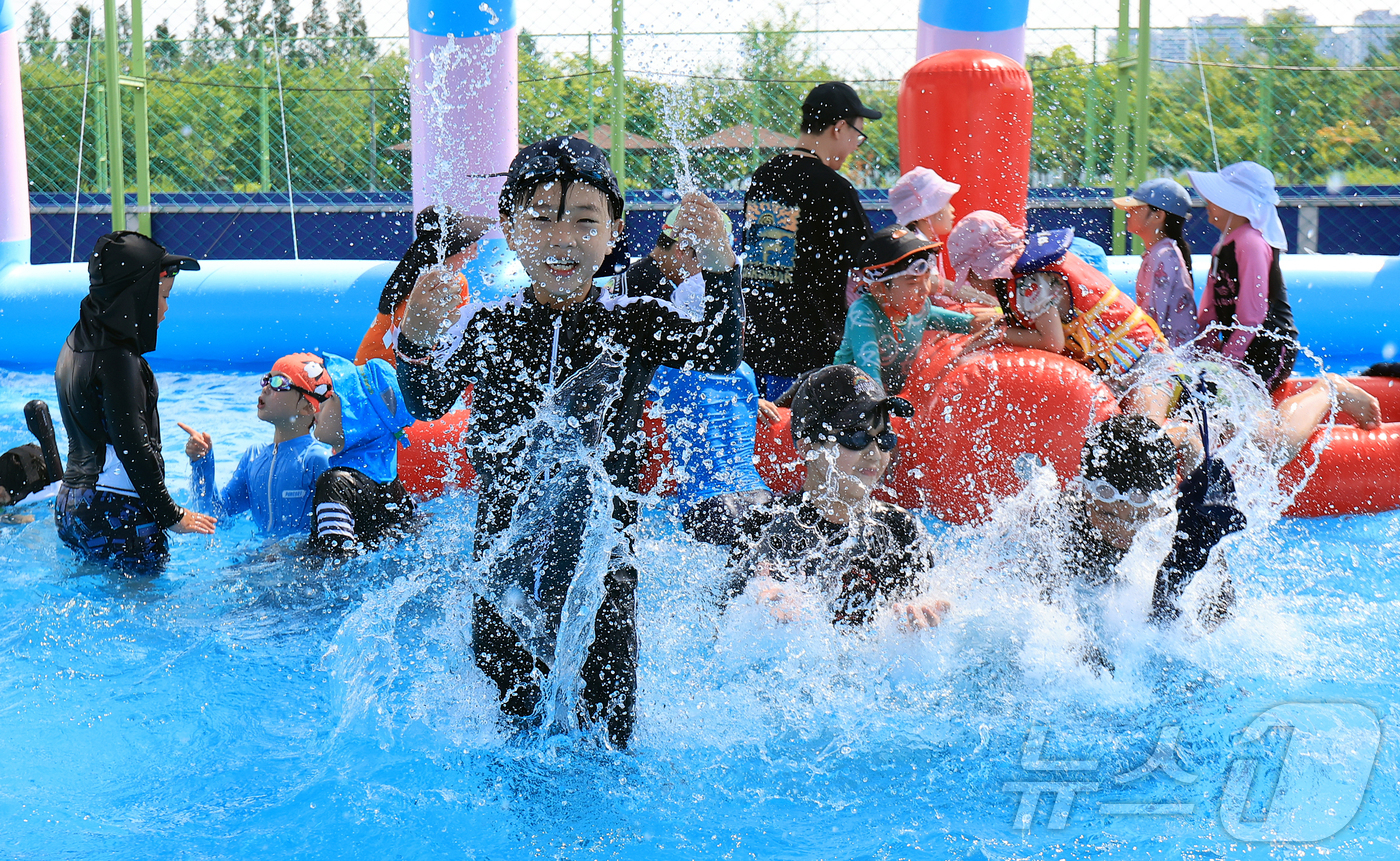 (서울=뉴스1) 김진환 기자 = 28일 오전 서울 강남구 일원에코파크 내 족구장에 마련된 물놀이장에서 어린이들이 물장구를 치며 무더위를 식히고 있다. 2025.7.28/뉴스1