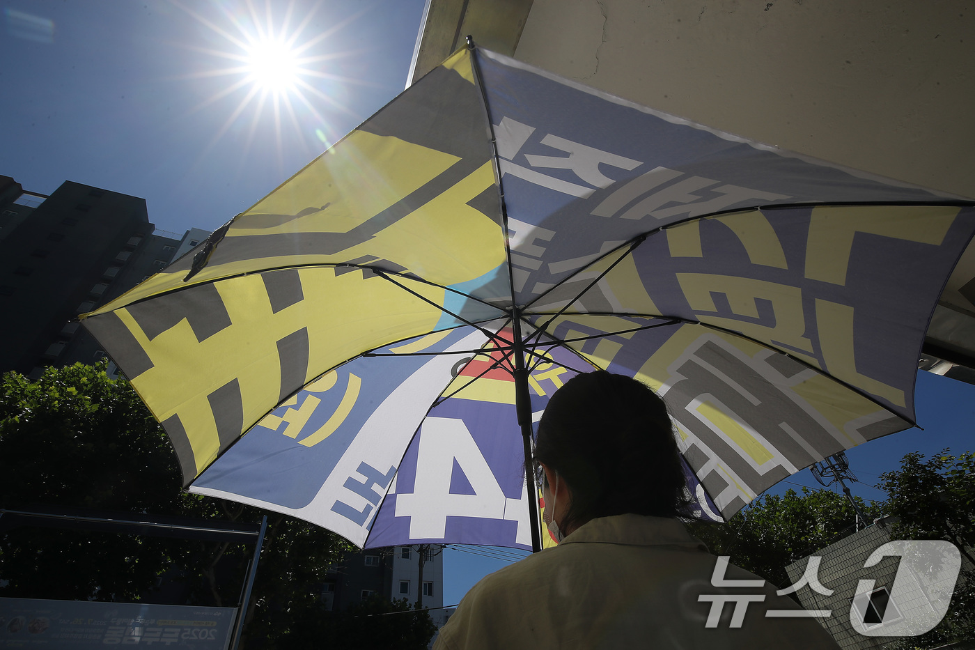 (대구=뉴스1) 공정식 기자 = 폭염이 이어진 28일 오전 대구 동구의 한 행정복지센터에서 민원인이 폐현수막을 재활용해 만든 양산을 빌려 가고 있다.  2025.7.28/뉴스1