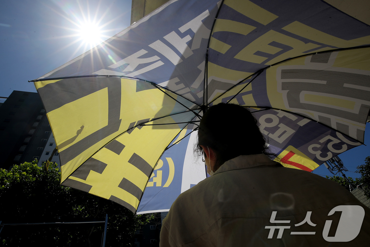 (대구=뉴스1) 공정식 기자 = 폭염이 이어진 28일 오전 대구 동구의 한 행정복지센터에서 민원인이 폐현수막을 재활용해 만든 양산을 빌려 가고 있다.  2025.7.28/뉴스1