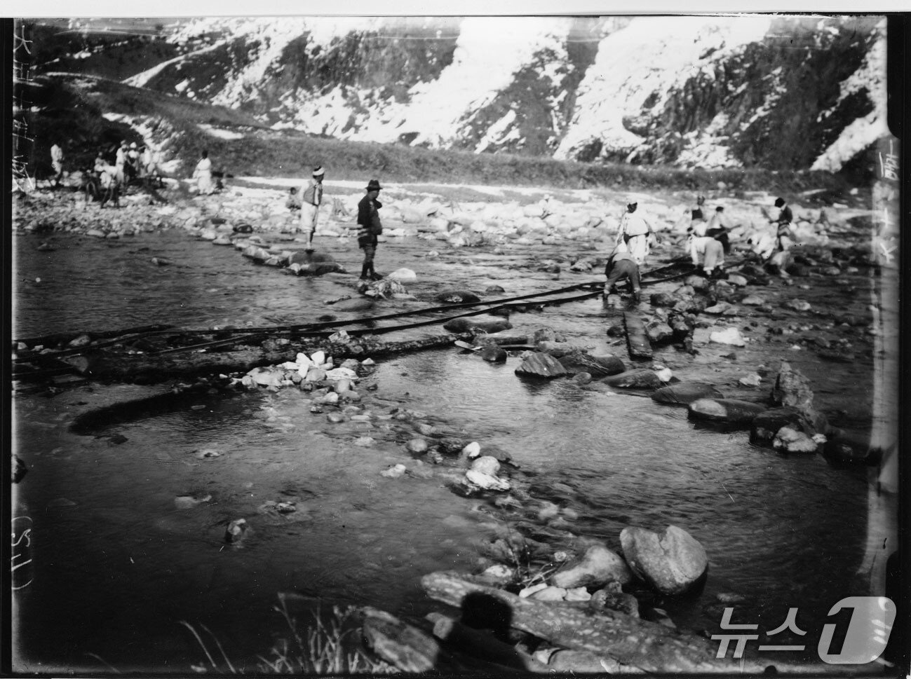 본문 이미지 - 일제에 의해 제천시 한수면 송계리 월광사지에서 반출되고 있는 원랑선사탑비가 개천을 넘고 있다. 일본 순사로 보이는 인물이 반출 과정을 지켜보고 있다.(제천문화원 제공. 재판매 및 DB금지)/뉴스1   