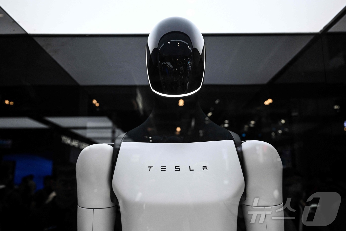 (상하이 AFP=뉴스1) 권영미 기자 = 28일 중국 상하이에서 열린 세계 인공지능콘퍼런스(WAIC)에서 테슬라 부스에 전시된 테슬라 봇이 관람객들의 눈길을 끌고 있다.2025.0 …