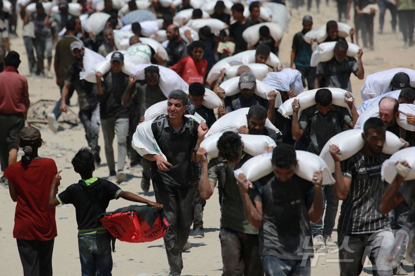 본문 이미지 - 공중 투하된 구호품을 옮기는 가자지구 주민들. 2025.07.27. ⓒ AFP=뉴스1 ⓒ News1 이지예 객원기자