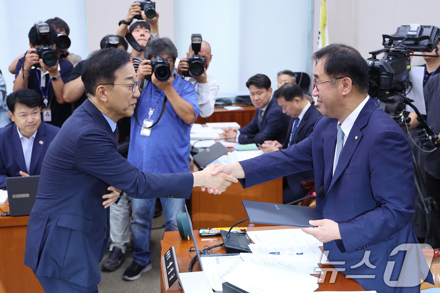 본문 이미지 - 김윤덕 국토교통부 장관 후보자&#40;왼쪽&#41;가 29일 오전 서울 여의도 국회 국토교통위원회에서 열린 인사청문회에서 맹성규 위원장에게 선서문을 제출한 후 악수하고 있다. 2025.7.29/뉴스1 ⓒ News1 신웅수 기자