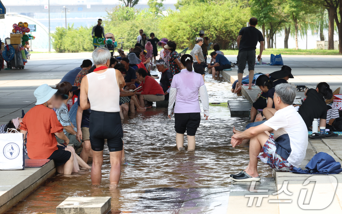 (서울=뉴스1) 김명섭 기자 = 연일 극한 폭염이 이어지고 있는 가운데 서울 마포대교 아래에서 시민들이 족욕을 하며 휴식을 취하고 있다. 2025.7.29/뉴스1