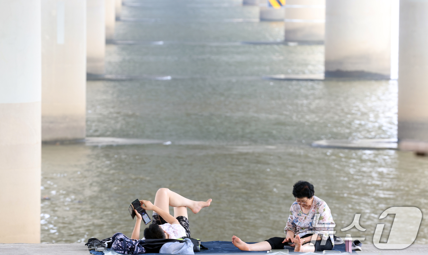 (서울=뉴스1) 김명섭 기자 = 연일 극한 폭염이 이어지고 있는 가운데 서울 마포대교 아래에서 시민들이 휴식을 취하고 있다. 2025.7.29/뉴스1