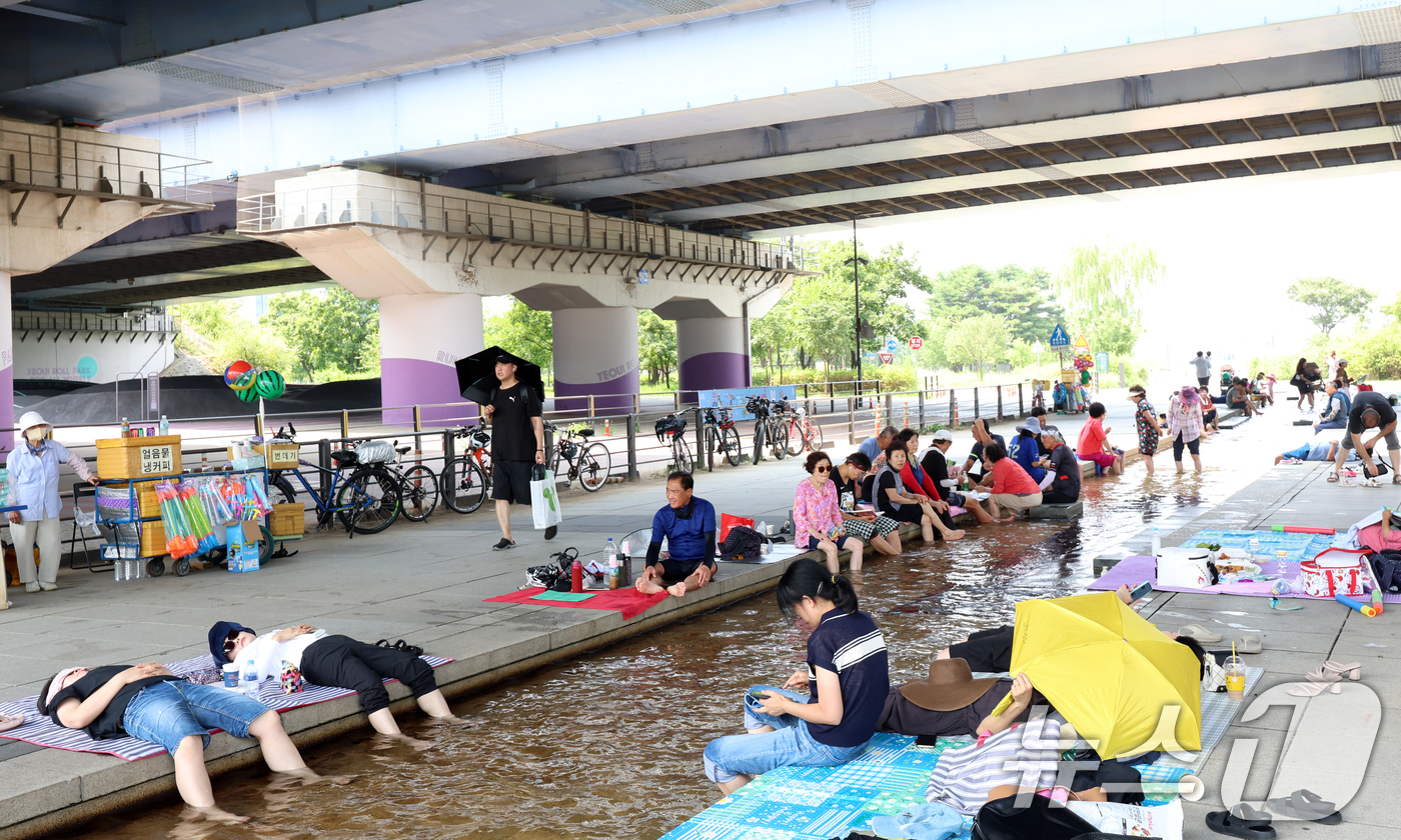 (서울=뉴스1) 김명섭 기자 = 연일 극한 폭염이 이어지고 있는 가운데 서울 마포대교 아래에서 시민들이 족욕을 하며 휴식을 취하고 있다. 2025.7.29/뉴스1