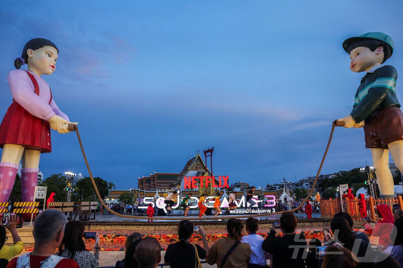 본문 이미지 - 지난 30일(현지시간) 태국 방콩 시청 광장에서 열린 '오징어 게임 3' 홍보 행사에서 시민들이 줄넘기 게임을 하고 있다. ⓒ 로이터=뉴스1