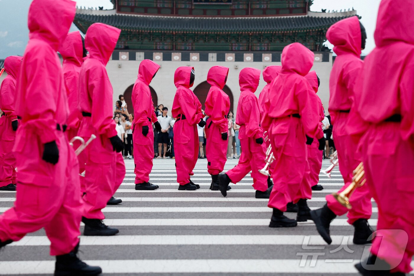 본문 이미지 - 지난 28일 서울 광화문광장에서 열린 '오징어 게임 3' 홍보 행사에서 캐릭터로 분장한 사람들이 행진을 하고 있다. ⓒ 로이터=뉴스1