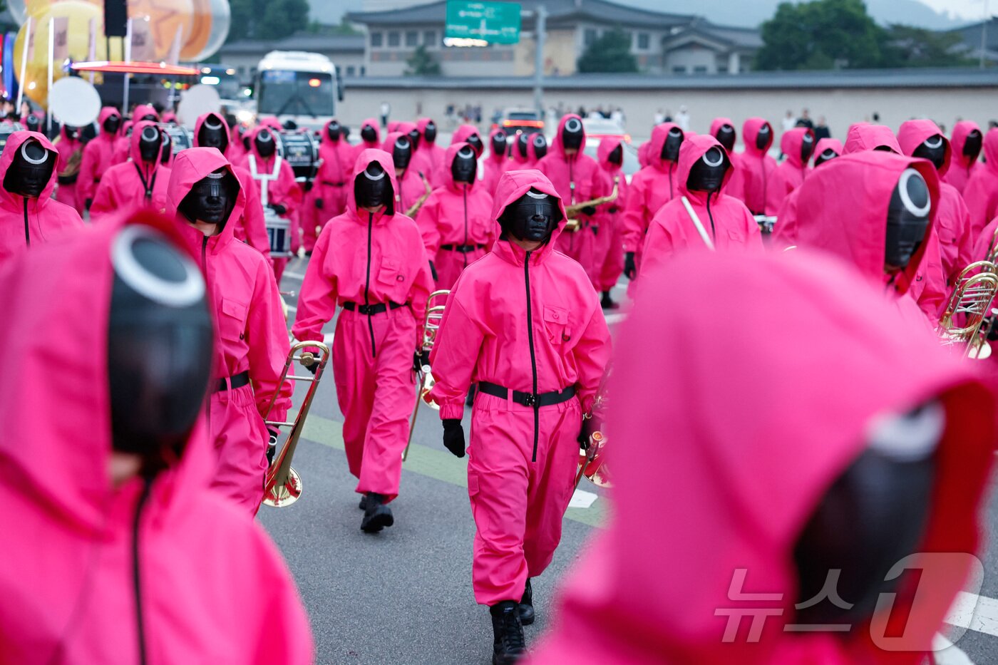 본문 이미지 - 지난 28일 서울 광화문광장에서 열린 '오징어 게임 3' 홍보 행사에서 캐릭터로 분장한 사람들이 행진을 하고 있다ⓒ 로이터=뉴스1