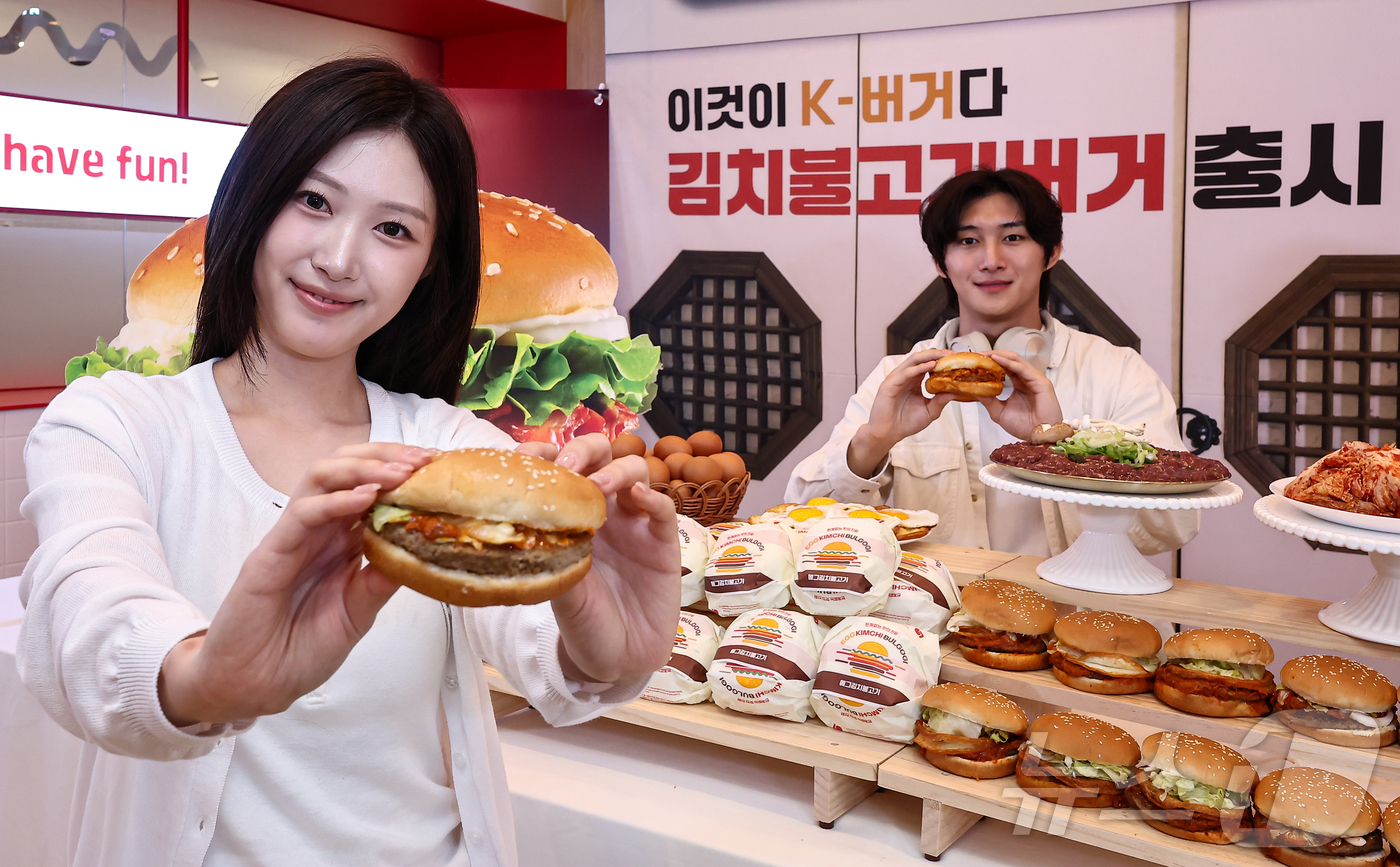 (서울=뉴스1) 김도우 기자 = 3일 서울 용산구 롯데리아 숙대입구역점에서 모델들이 신메뉴 '김치불고기버기' 2종을 소개하고 있다.롯데리아는 이날 불고기와 볶은 김치를 활용한 김치 …