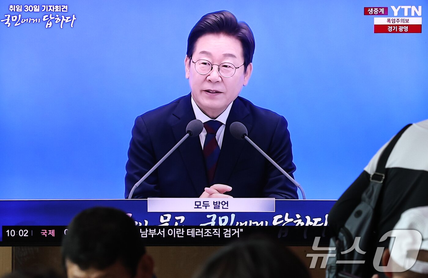 본문 이미지 - 3일 오전 서울역 대합실에서 시민들이 이재명 대통령 ‘취임 한달’ 기자회견 생중계 영상을 시청하고 있다. 2025.7.3/뉴스1 ⓒ News1 구윤성 기자