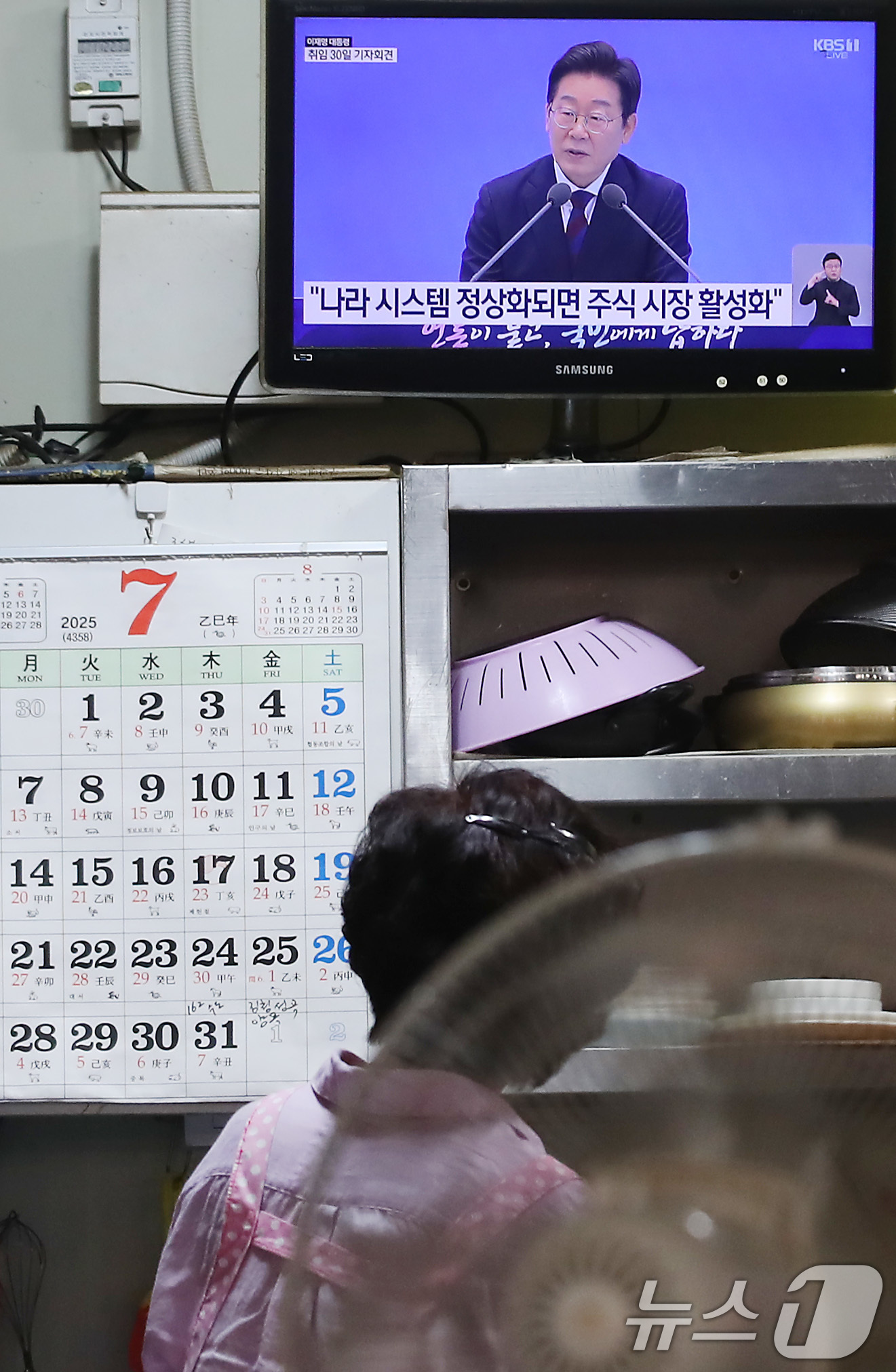 (대구=뉴스1) 공정식 기자 = 3일 오전 대구 중구의 한 전통시장 내 식당에서 상인이 텔레비전을 통해 '이재명 대통령 취임 30일' 기자회견을 시청하고 있다. 2025.7.3/뉴 …