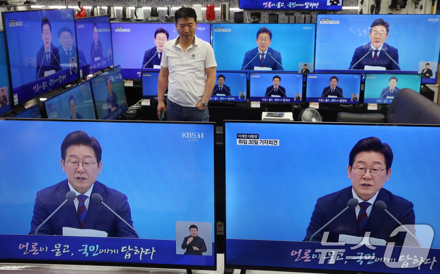 본문 이미지 - 3일 서울 용산구 전자랜드 매장에서 상인이 &#39;대통령의 30일, 언론이 묻고 국민에게 답하다&#39;라는 이재명 대통령 기자회견을 보고 있다. 2025.7.3/뉴스1 ⓒ News1 김명섭 기자