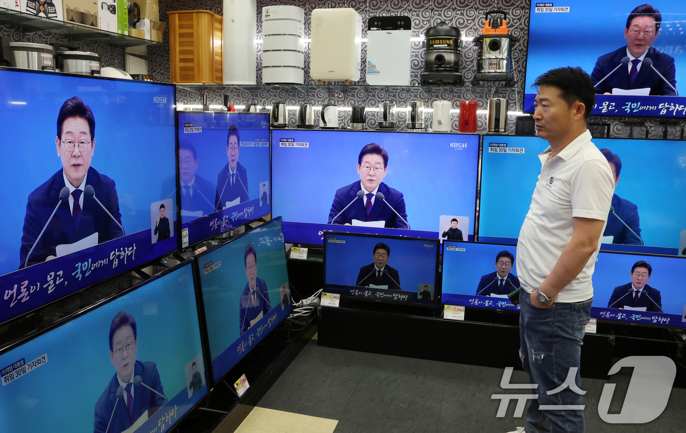 (서울=뉴스1) 김명섭 기자 = 3일 서울 용산구 전자랜드 매장에서 상인이 '대통령의 30일, 언론이 묻고 국민에게 답하다'라는 이재명 대통령 기자회견을 보고 있다. 2025.7. …