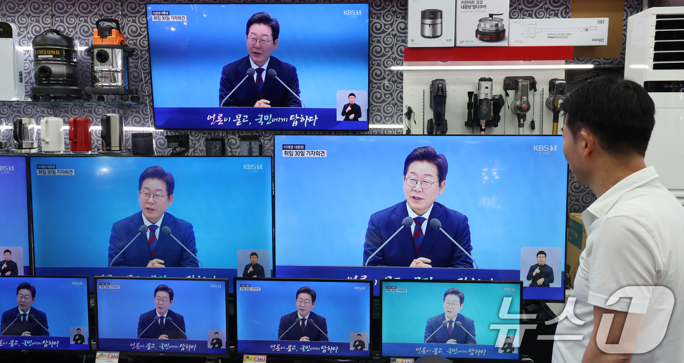 (서울=뉴스1) 김명섭 기자 = 3일 서울 용산구 전자랜드 매장에서 상인이 '대통령의 30일, 언론이 묻고 국민에게 답하다'라는 이재명 대통령 기자회견을 보고 있다. 2025.7. …