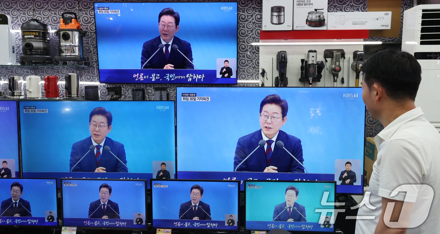 본문 이미지 - 3일 서울 용산구 전자랜드 매장에서 상인이 &#39;대통령의 30일, 언론이 묻고 국민에게 답하다&#39;라는 이재명 대통령 기자회견을 보고 있다. 2025.7.3/뉴스1 ⓒ News1 김명섭 기자