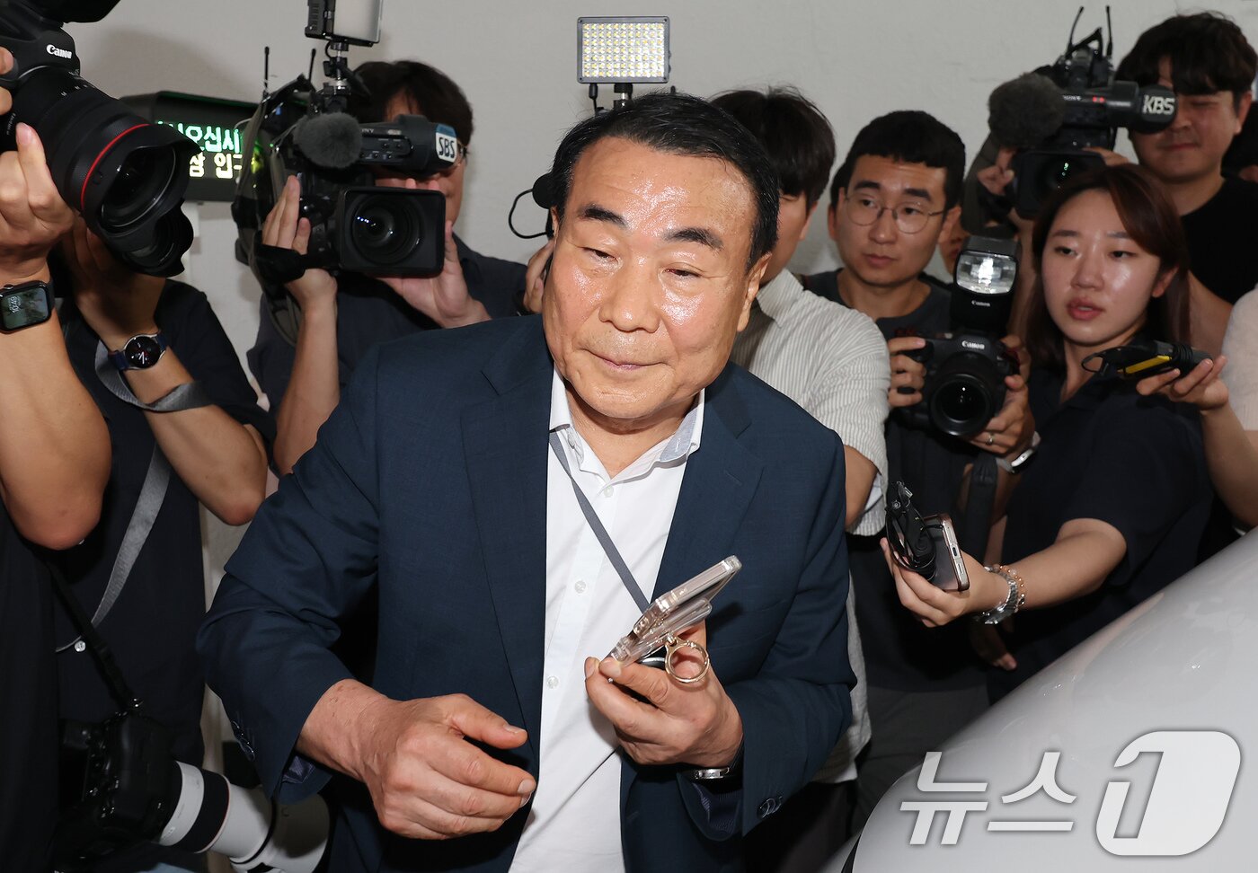 본문 이미지 - 윤석열 전 대통령 배우자 김건희 여사 의혹을 수사하는 민중기 특별검사팀 관계자가 3일 오전 서울 종로구 삼부토건에 대한 압수수색 중 건물 밖에서 전화기를 든 채 이동하고 있다. 2025.7.3/뉴스1 ⓒ News1 장수영 기자