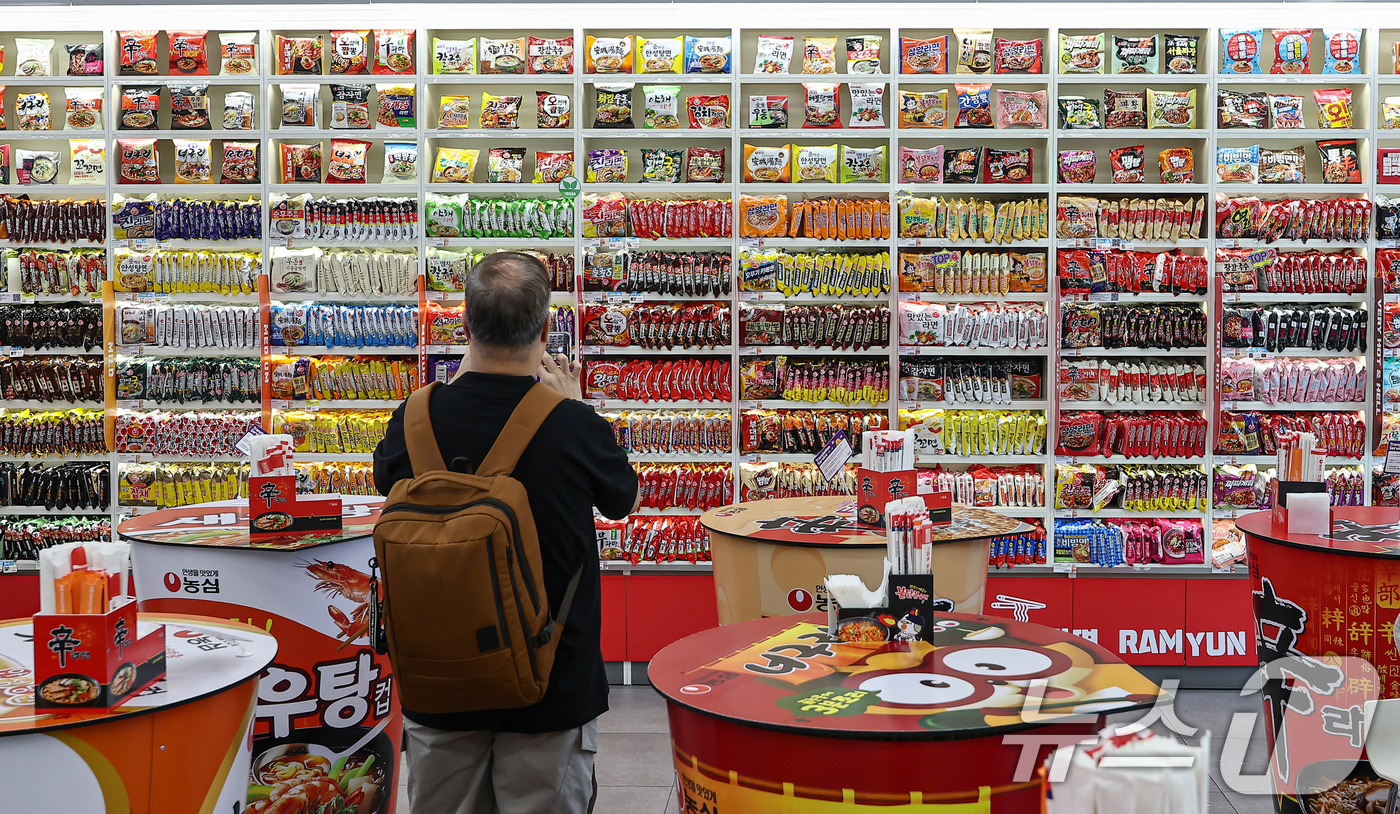 (서울=뉴스1) 김도우 기자 = 3일 서울 마포구 CU 홍대상상점 라면 라이브러리를 찾은 고객이 라면을 살펴보고 있다.올해 상반기 K-푸드 플러스(K-Food+) 수출이 전년 동기 …