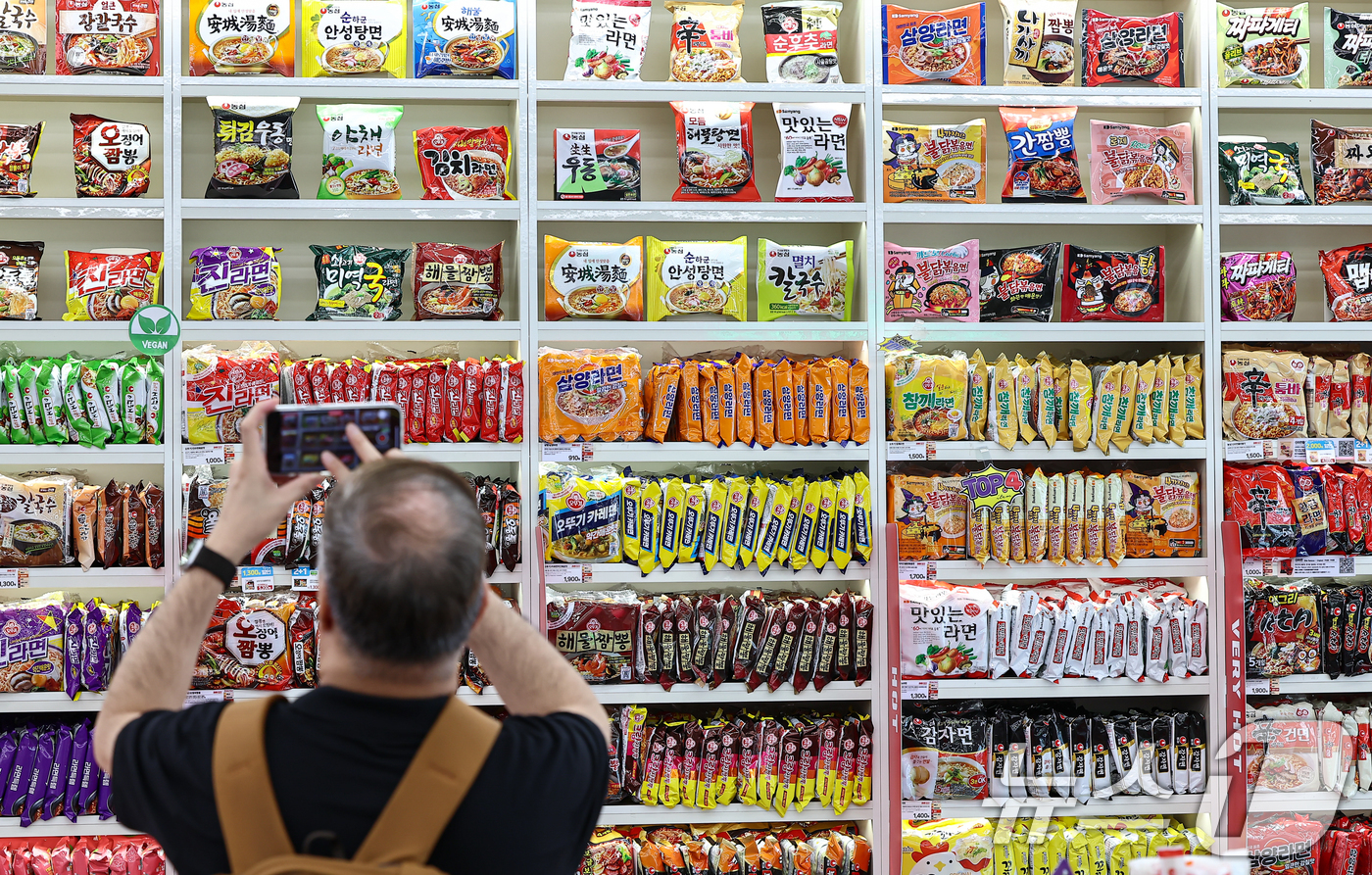 (서울=뉴스1) 김도우 기자 = 3일 서울 마포구 CU 홍대상상점 라면 라이브러리를 찾은 고객이 라면을 살펴보고 있다.올해 상반기 K-푸드 플러스(K-Food+) 수출이 전년 동기 …