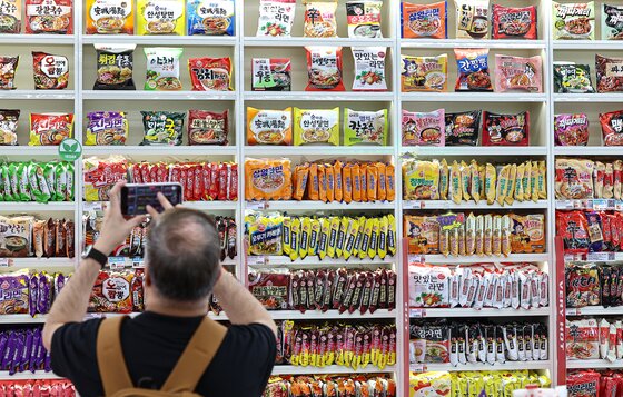 본문 이미지 - 서울 마포구 CU 홍대상상점 라면 라이브러리를 찾은 고객이 라면을 살펴보고 있다.  2025.7.3/뉴스1 ⓒ News1 김도우 기자