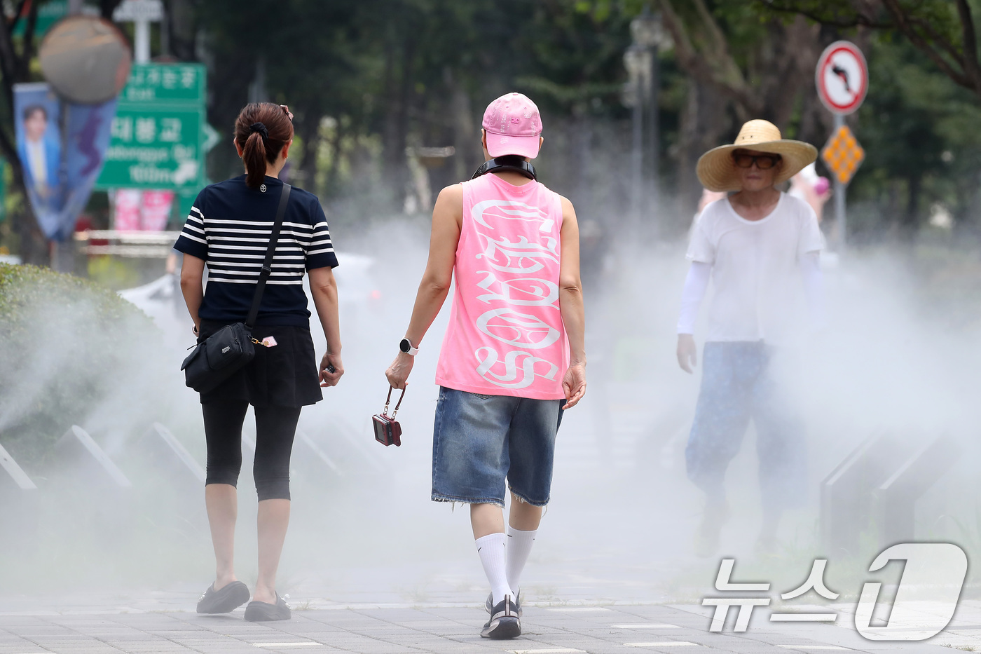 (대구=뉴스1) 공정식 기자 = 일주일째 폭염특보가 이어진 3일 대구 중구 김광석길 입구에 가동된 쿨링포그 사이로 시민들이 다양한 패션을 선보이며 걷고 있다. 2025.7.3/뉴스 …