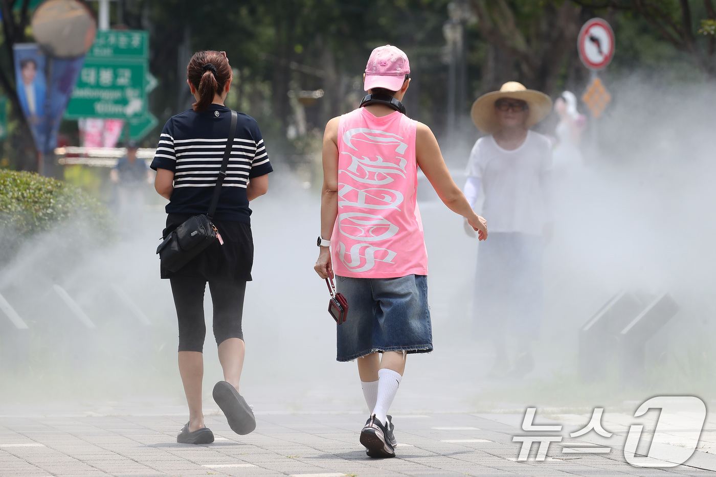 (대구=뉴스1) 공정식 기자 = 일주일째 폭염특보가 이어진 3일 대구 중구 김광석길 입구에 가동된 쿨링포그 사이로 시민들이 다양한 패션을 선보이며 걷고 있다. 2025.7.3/뉴스 …
