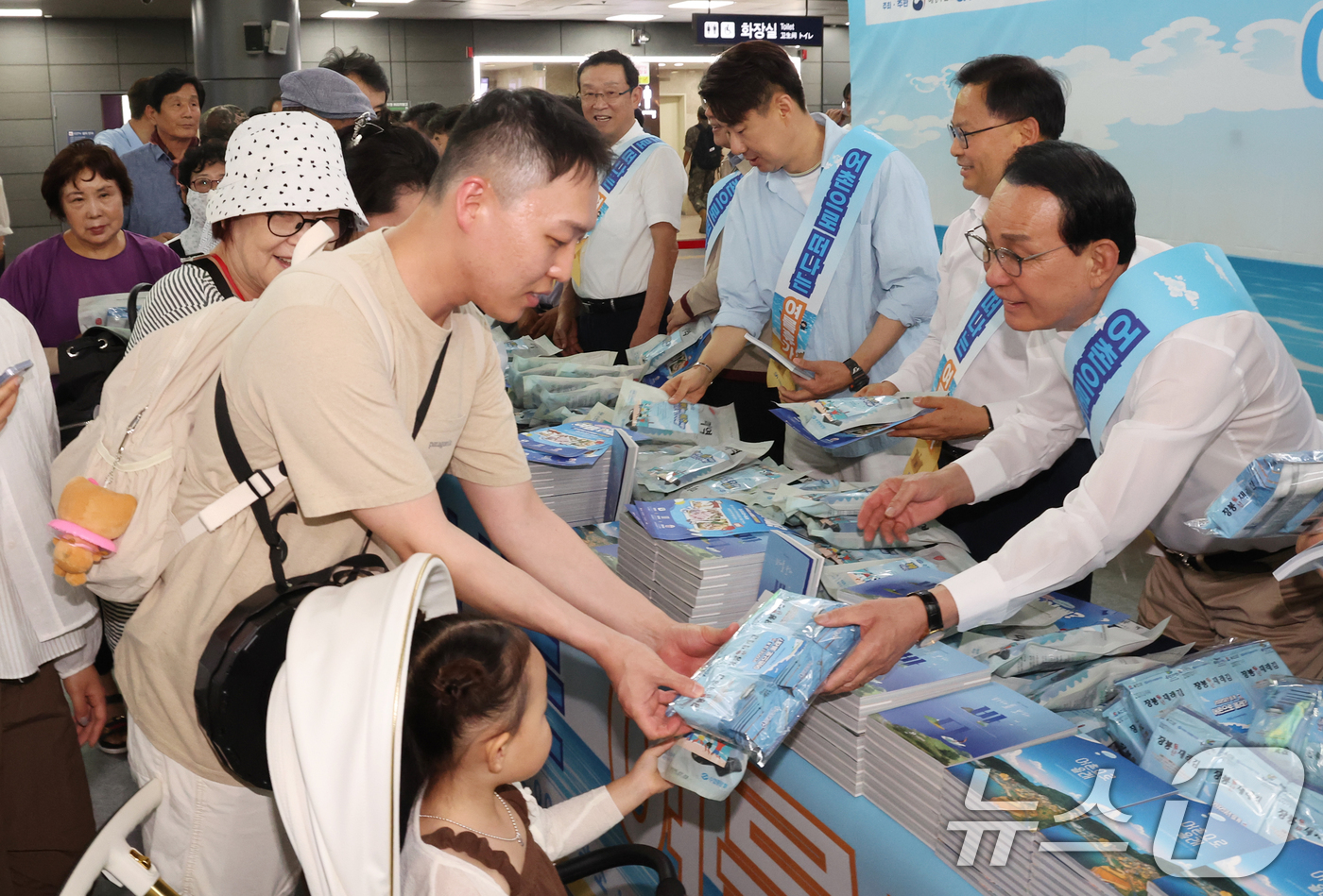 (서울=뉴스1) 김명섭 기자 = 노동진 수협중앙회장이 30일 서울 SRT수서역에서 열린 여름휴가 어촌에서 보내기 캠페인에서 시민들에게 여름철 휴가지로 각광받는 어촌마을 안내 책자인 …