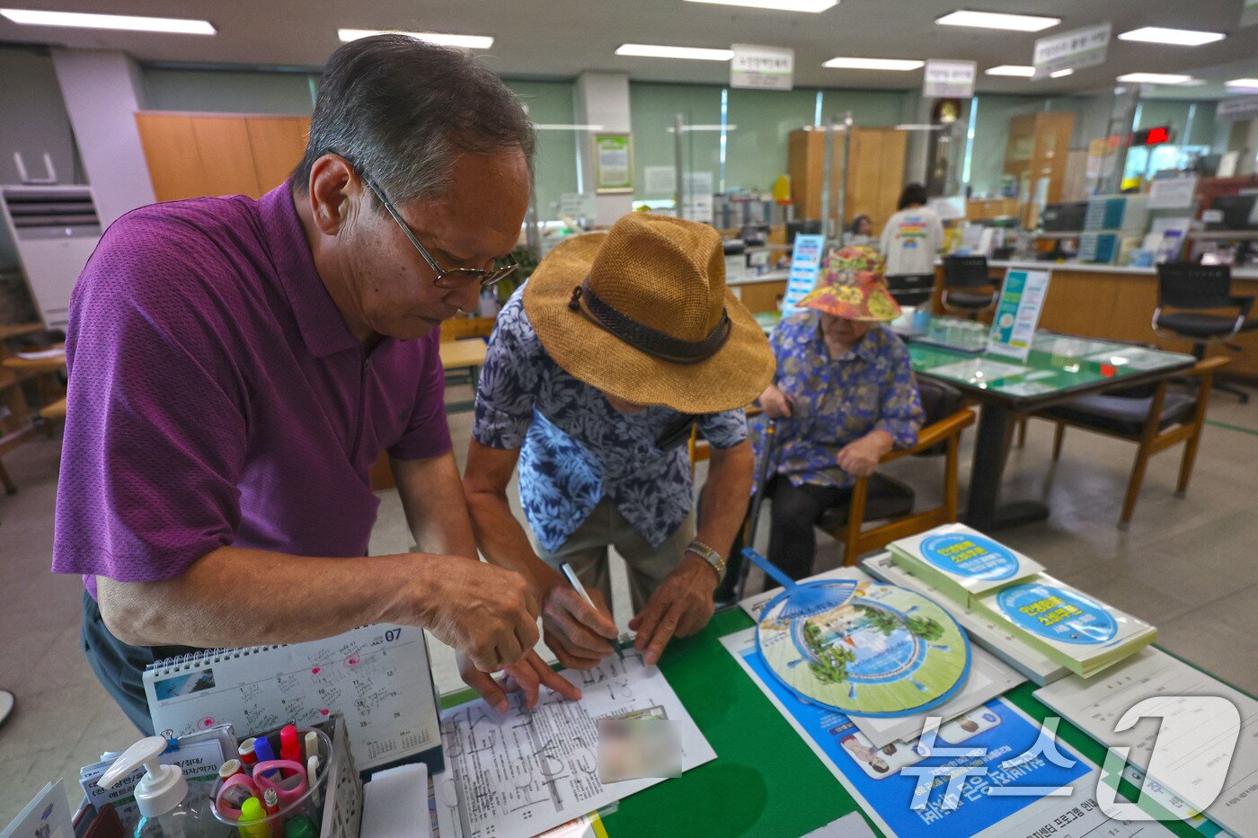 본문 이미지 - 30일 광주 남구 주월1동 행정복지센터에 90대 어르신이 민생지원 소비쿠폰을 받기 위해 서류를 작성하고 있다. 2025.7.30/뉴스1 ⓒ News1 박지현 기자