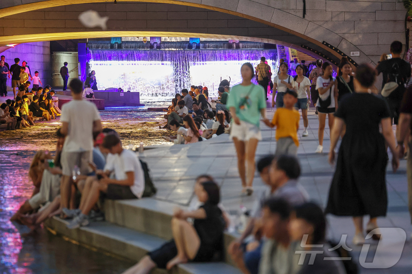 (서울=뉴스1) 민경석 기자 = 뜨겁고 습한 날씨가 이어지며 열대야 현상 발생이 전망된 30일 저녁 서울 중구 청계천을 찾은 시민들이 물에 발을 담그는 등 산책을 즐기며 무더위를 …