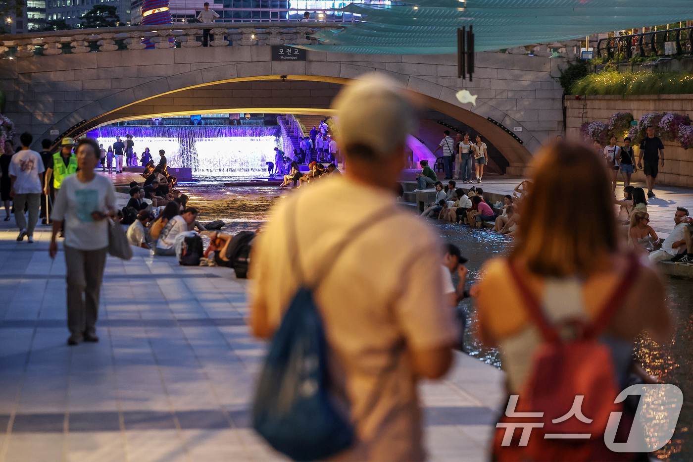 (서울=뉴스1) 민경석 기자 = 뜨겁고 습한 날씨가 이어지며 열대야 현상 발생이 전망된 30일 저녁 서울 중구 청계천을 찾은 시민들이 물에 발을 담그는 등 산책을 즐기며 무더위를 …