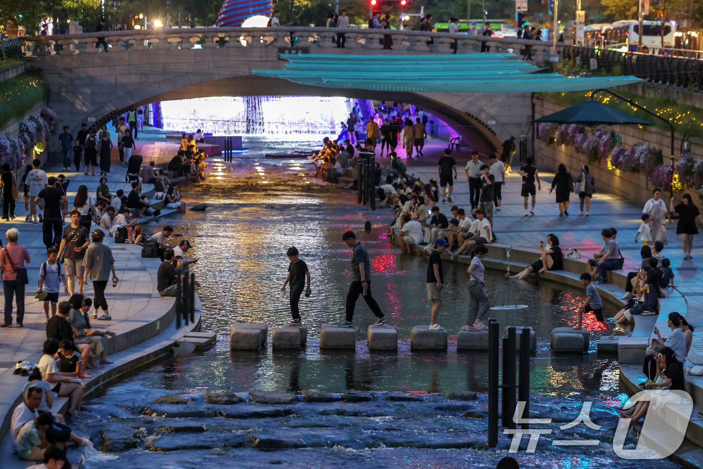 (서울=뉴스1) 민경석 기자 = 뜨겁고 습한 날씨가 이어지며 열대야 현상 발생이 전망된 30일 저녁 서울 중구 청계천을 찾은 시민들이 물에 발을 담그는 등 산책을 즐기며 무더위를 …