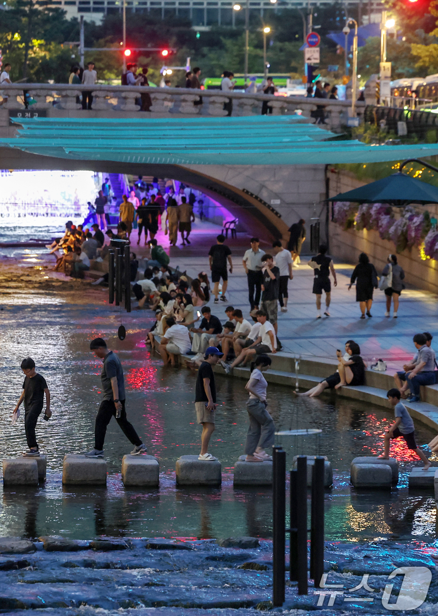(서울=뉴스1) 민경석 기자 = 뜨겁고 습한 날씨가 이어지며 열대야 현상 발생이 전망된 30일 저녁 서울 중구 청계천을 찾은 시민들이 물에 발을 담그는 등 산책을 즐기며 무더위를 …