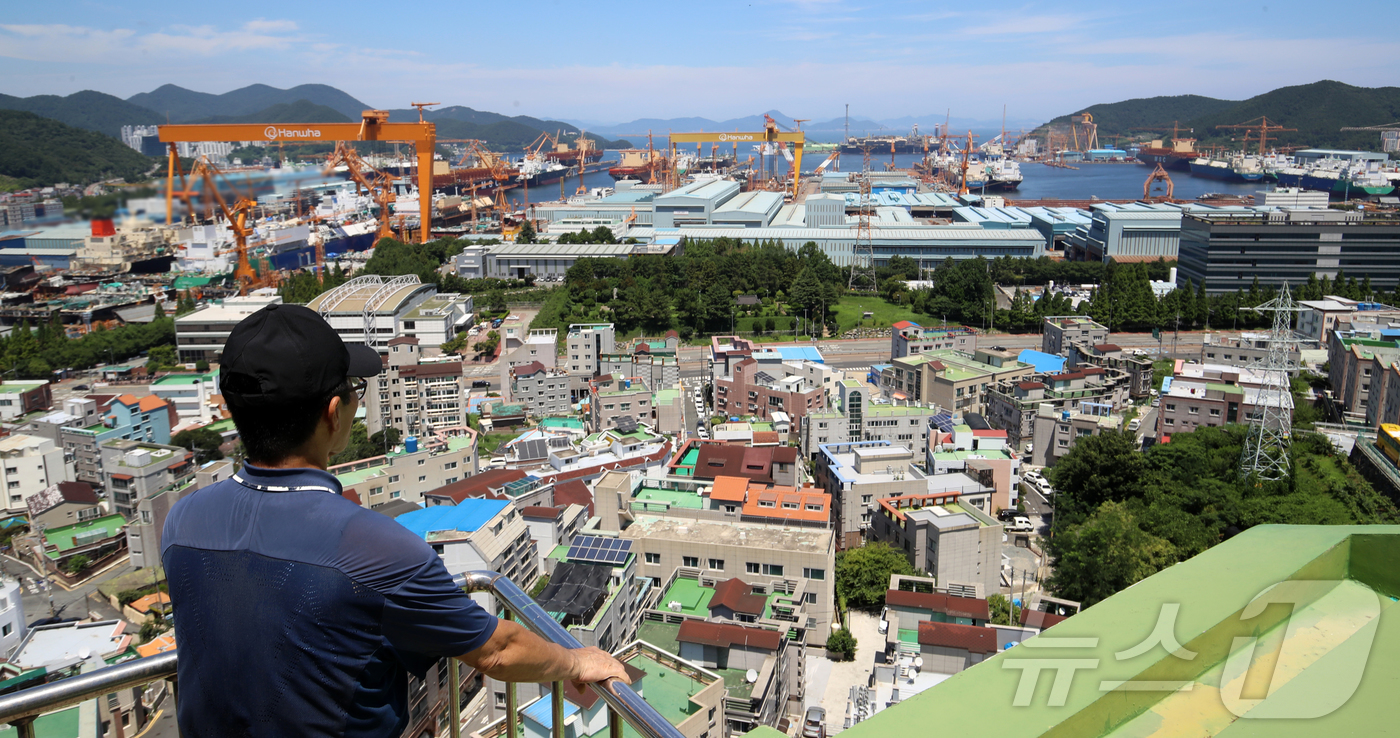 (거제=뉴스1) 윤일지 기자 = 대미 수출 관세 인하와 조선업 투자를 골자로 한 한미 무역 협상이 타결된 31일 한 시민이 경남 거제시 아주동 주거단지 너머로 한화오션 거제사업장 …