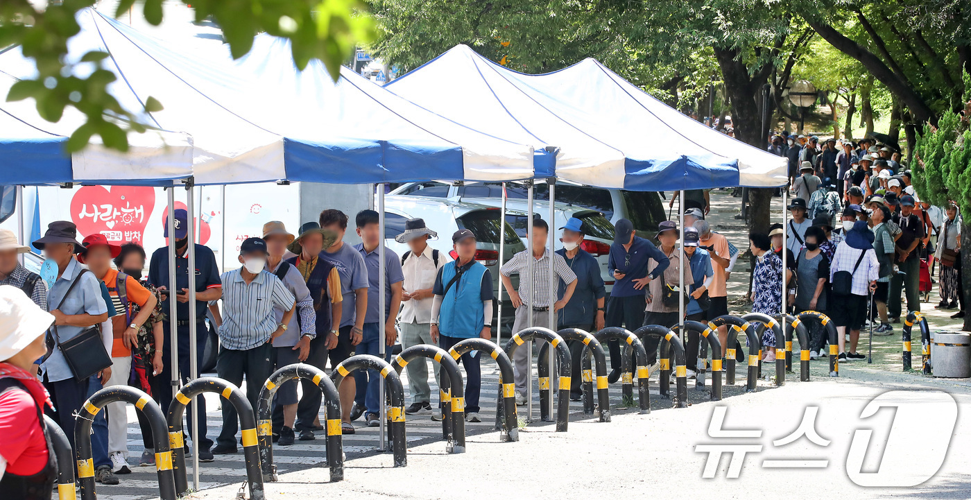 (대구=뉴스1) 공정식 기자 = 폭염이 계속된 31일 대구 달서구 두류공원 사랑해밥차 무료급식소 앞에 많은 사람들이 줄지어 점심 배식을 기다리고 있다. 2025.7.31/뉴스1