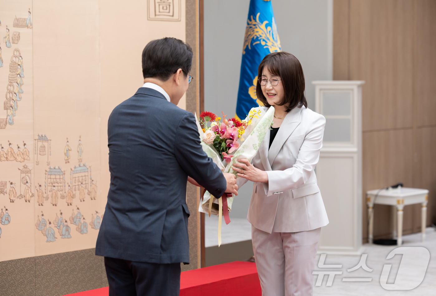 (서울=뉴스1) 이재명 기자 = 이재명 대통령이 4일 서울 용산 대통령실 청사에서 열린 임명장 수여식에서 김민석 신임 국무총리 배우자에게 꽃다발을 전달하고 있다. (대통령실 제공. …