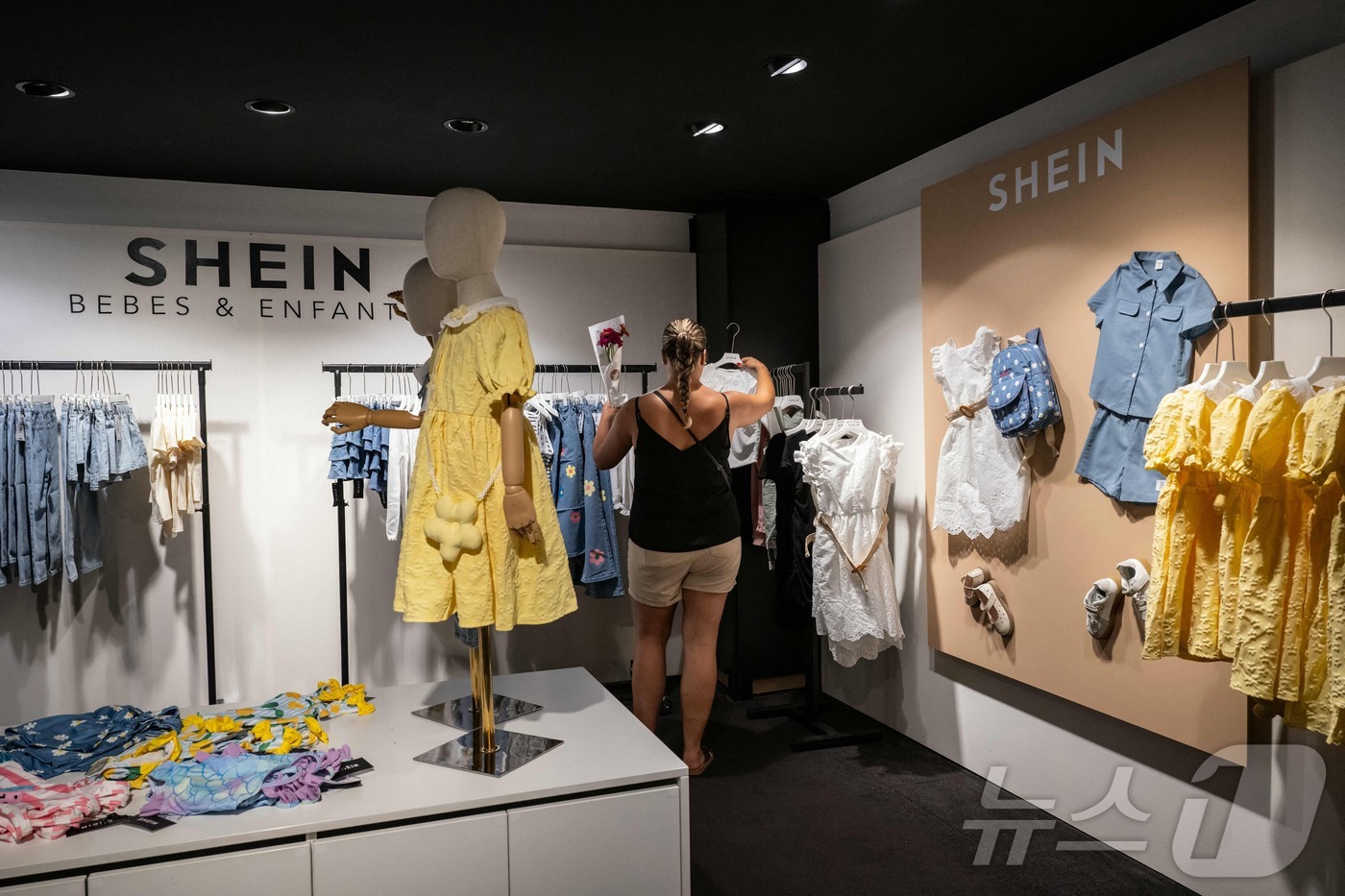 (디죵 AFP=뉴스1) 권영미 기자 = 프랑스 디죵의 한 쉬인 매장에서 고객이 옷을 살펴보고 있다. 2025.06.26.ⓒ AFP=뉴스1