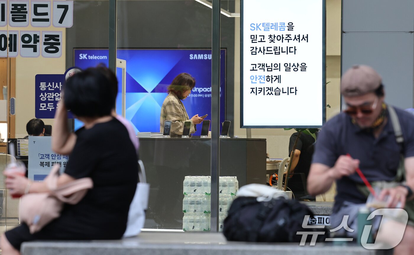 본문 이미지 - 정부가 SK텔레콤 해킹 사고 조사 결과를 토대로 위약금 면제 규정 적용이 가능하다고 밝힌 4일 오후 서울의 한 SKT 공식매장을 찾은 시민이 상담을 받고 있다. 2025.7.4/뉴스1 ⓒ News1 장수영 기자