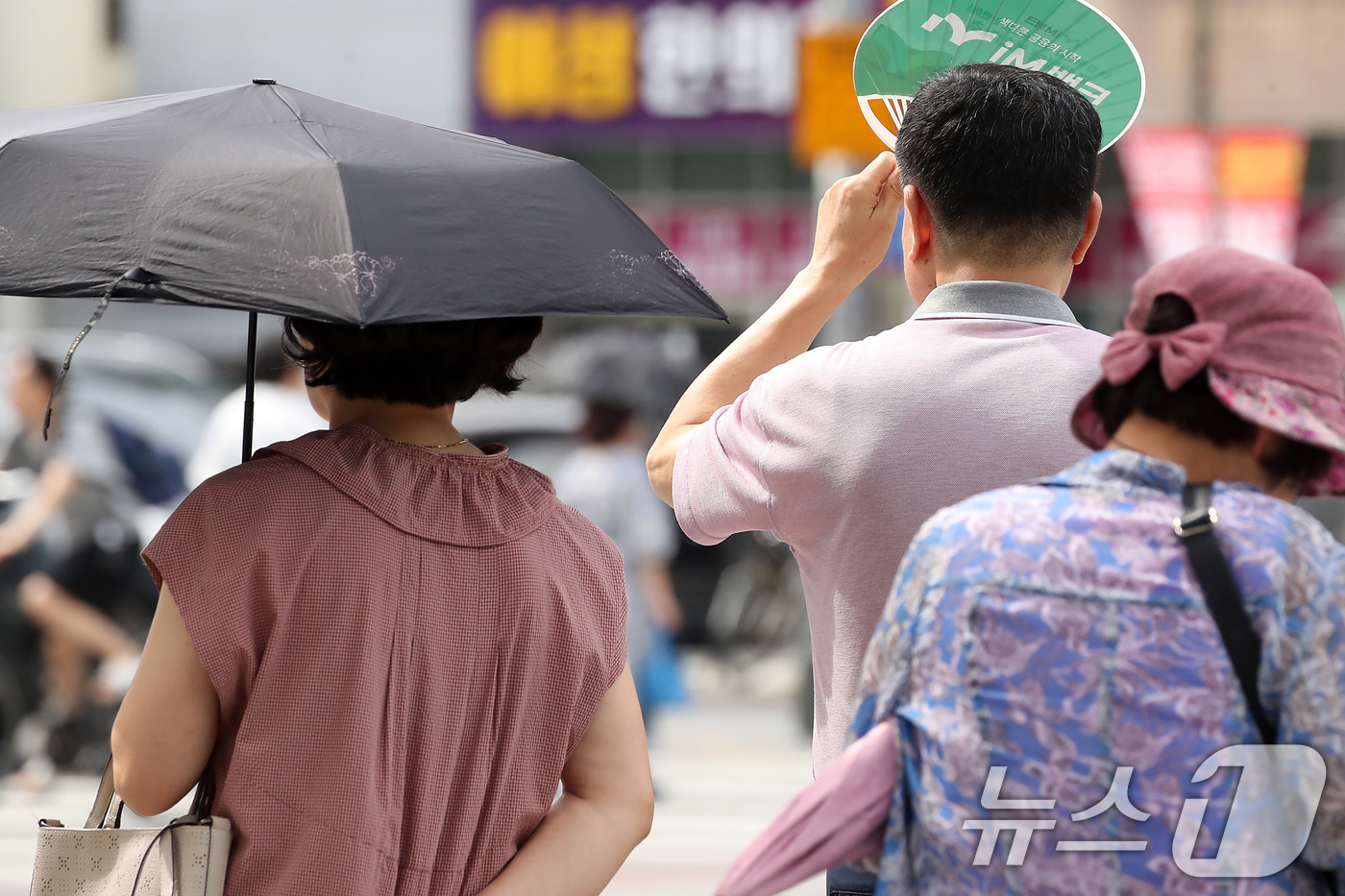 (대구=뉴스1) 공정식 기자 = 폭염이 일주일 넘게 이어진 4일 오후 대구 수성구 달구벌대로에서 시민들이 양산과 부채로 뙤약볕을 가리고 있다. 2025.7.4/뉴스1