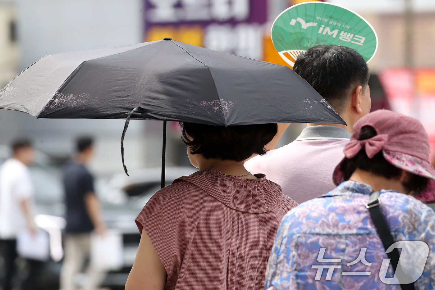 (대구=뉴스1) 공정식 기자 = 폭염이 일주일 넘게 이어진 4일 오후 대구 수성구 달구벌대로에서 시민들이 양산과 부채로 뙤약볕을 가리고 있다. 2025.7.4/뉴스1