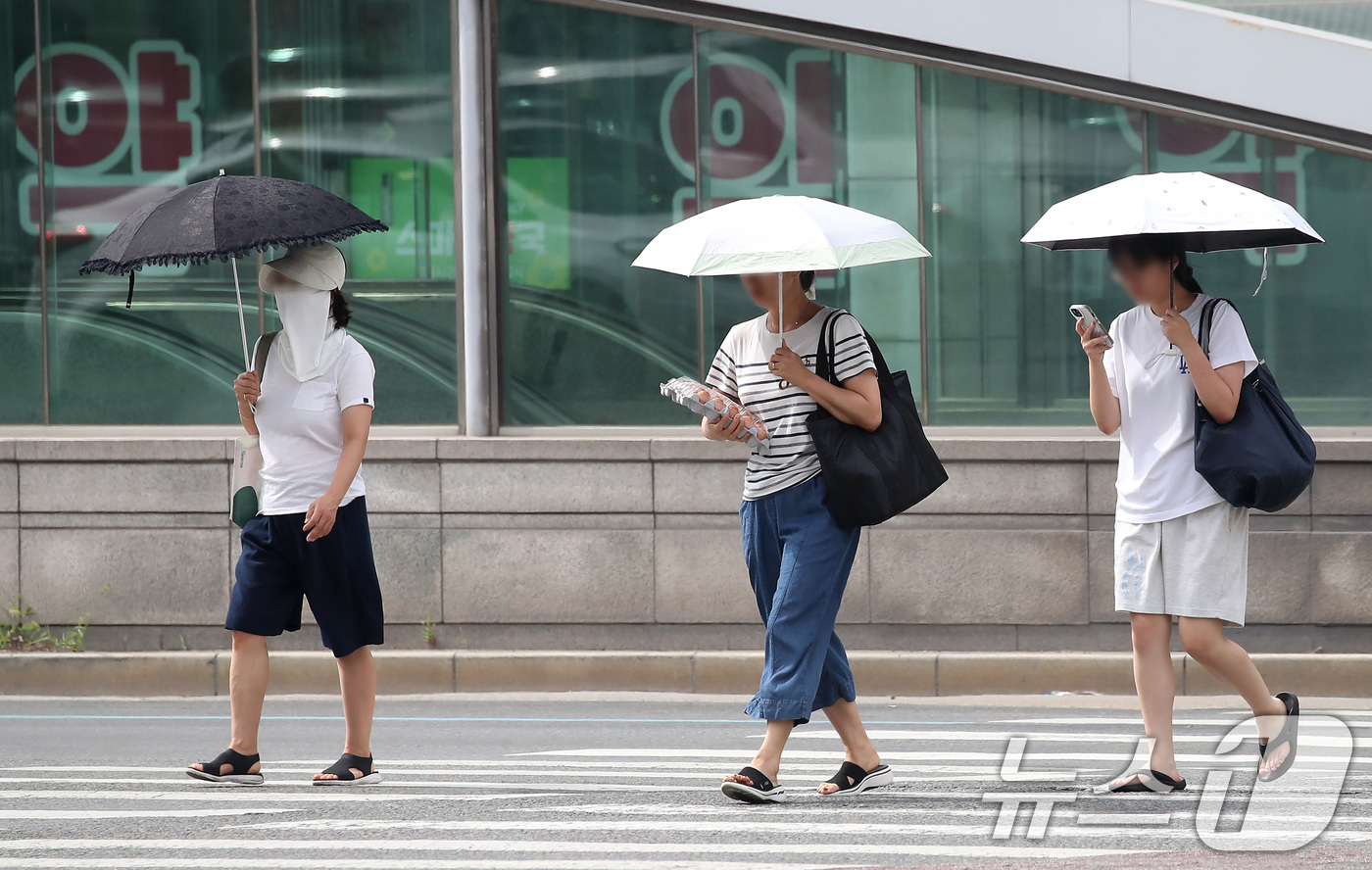 (대구=뉴스1) 공정식 기자 = 폭염이 일주일 넘게 이어진 4일 오후 대구 수성구 달구벌대로에서 시민들이 양산을 펼쳐 뙤약볕을 피하고 있다. 2025.7.4/뉴스1