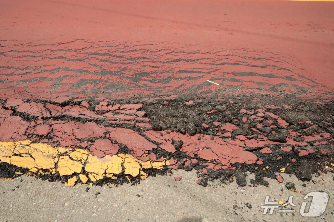 본문 이미지 - 4일 울산 북구 농소초등학교 앞 버스정류장 도로변. 도로의 아스팔트가 마치 녹은 아이스크림처럼 밀려나 있다.2025.7.4./뉴스1 김세은 기자
