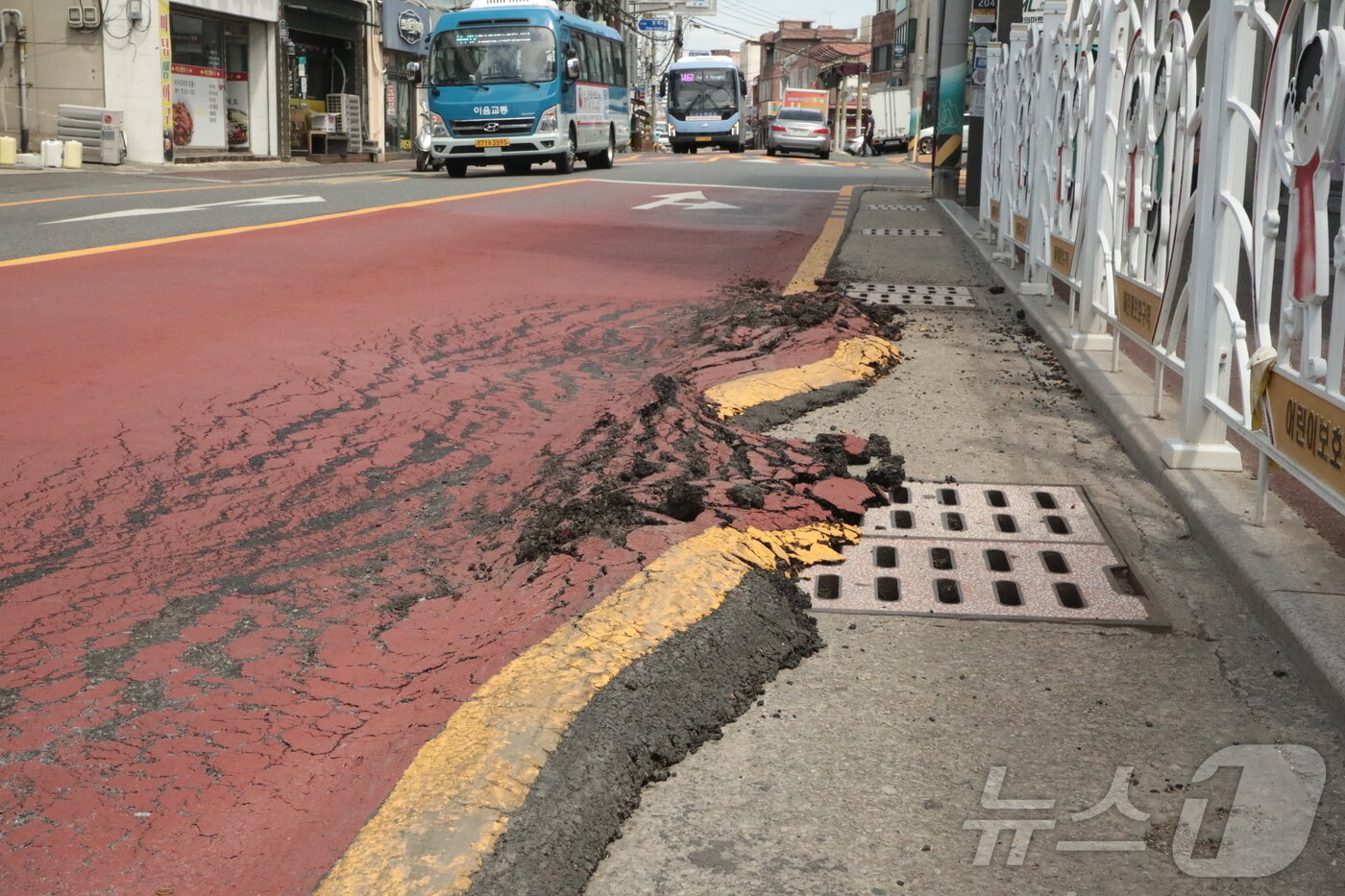 본문 이미지 - 4일 울산 북구 농소초등학교 앞 버스정류장 도로변의 아스팔트가 마치 녹은 아이스크림처럼 밀려나 있다. 고온에 달궈진 아스팔트가 대형 차량의 하중으로 인해 밀려 솟아오르는 &#39;소성변형&#39;의 모습이다. ⓒ News1 김세은 기자