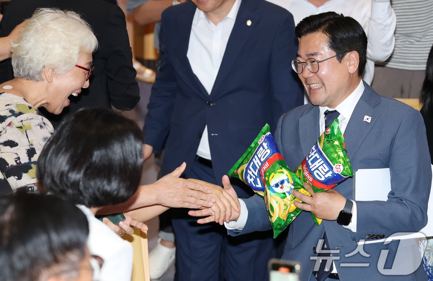 본문 이미지 - 더불어민주당 당대표 선거에 출마한 박찬대 의원이 5일 전북 전주시 전주대학교 JJ아트홀에서 열린 당찬대 원팀 토크콘서트에서 지지자에게 받은 &#39;찬대랑&#39;이라고 적힌 과자를 들고 입장하고 있다. 2025.7.5/뉴스1 ⓒ News1 유경석 기자
